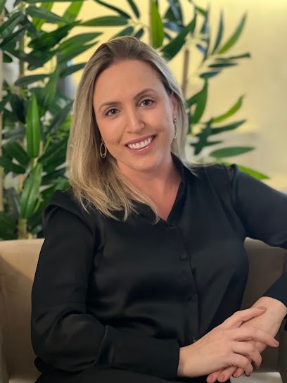 Natália Pappen Neitzke, psicóloga, sorrindo em seu consultório